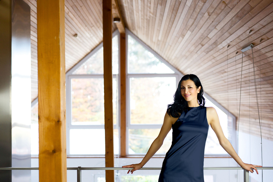 L'imprenditrice digitale erica holland indossa un vestito elegante color blu notte nella sua casa con travi di legno